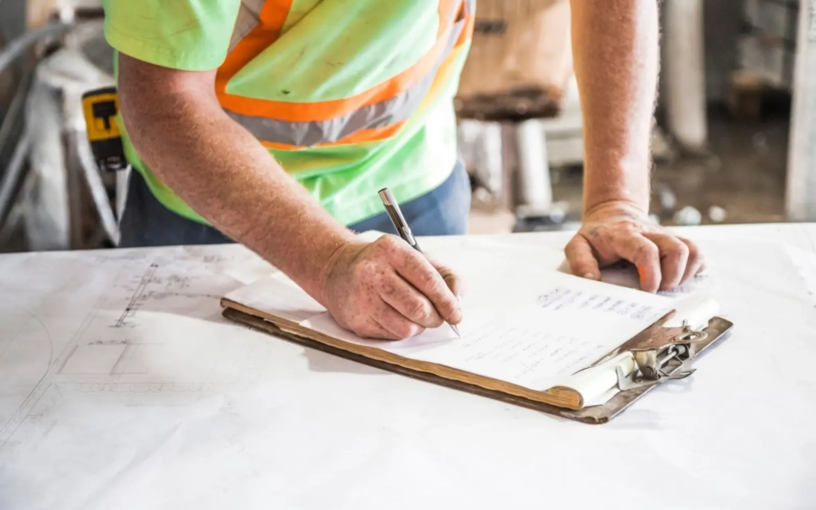 Site manager in hi-vis reviewing construction plans, representing construction website design