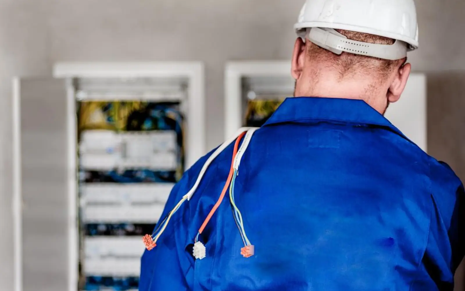 Electrician working at a fuse board, the tradesmen our web design for trades is built for